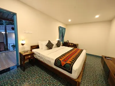 a hotel room with a bed and a balcony at Ibex Resorts, Coimbatore Kakarla in Alāndurai