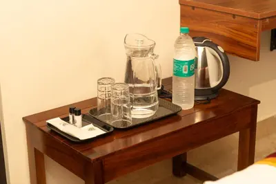 a table with glasses and a bottle of water on it at Pomma Holidays and Resorts in Muthanga