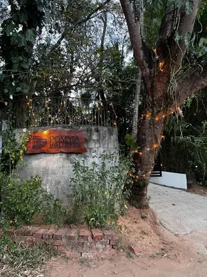 a sign on a wall next to a tree at Pomma Holidays and Resorts in Muthanga