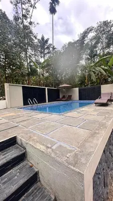 a swimming pool with two lounge chairs at Pomma Holidays and Resorts in Muthanga