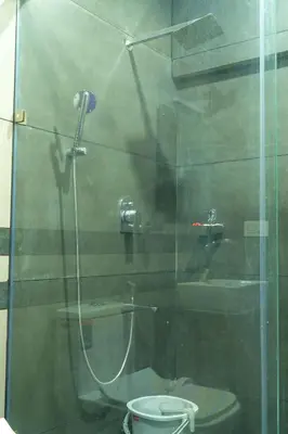 a bathroom with a glass shower with a toilet and a sink at Pomma Holidays and Resorts in Muthanga