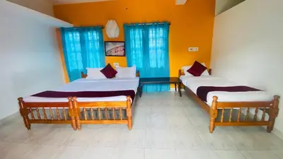 two beds in a room with yellow walls and blue windows at Mountain View Villas in Madikeri