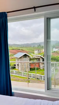 a bedroom window with a view of a field at Away From Home - 6 - Home Stay Ooty, Entire 3BHK Villa in Ooty