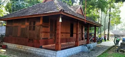 a small wooden house with a roof at Sparrow Vale Resort in Kotamangalam