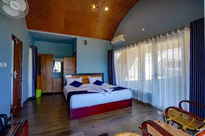 a bedroom with two beds and a large window at Ginberry Holidays in Wayanad