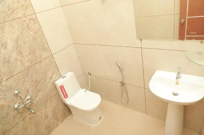 a bathroom with a toilet and a sink at Nilgiri Woodlands Luxury Service Apartments in Mysore