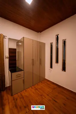 a room with a glass cabinet and a wooden floor at Rivana Homestay in Kushālnagar