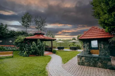 a garden with a gazebo and a bench at Green Nest Resort Ooty in Kotagiri
