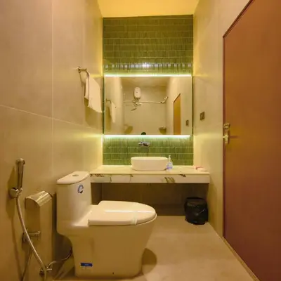 a bathroom with a toilet and a sink and a mirror at Ohstayz Villa De Estate 64 in Kizhake Chālakudi