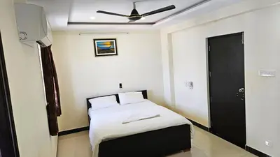 a bedroom with a bed and a ceiling fan at Rodas Serviced Apartment in Coimbatore