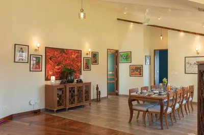 a dining room with a table and chairs at SaffronStays Coonoor Canvas in Coonoor