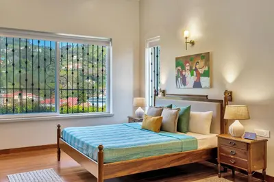 a bedroom with a bed and a large window at SaffronStays Coonoor Canvas in Coonoor