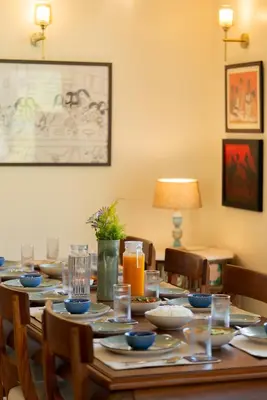 a wooden table with plates and dishes on it at SaffronStays Coonoor Canvas in Coonoor