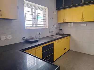 a kitchen with yellow cabinets and a sink at Golden Gate Luxury Villas by LexStays in Ooty