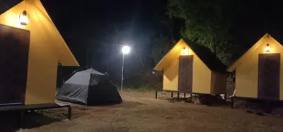 a group of tents in a field at night at Mount Camp in Marayoor