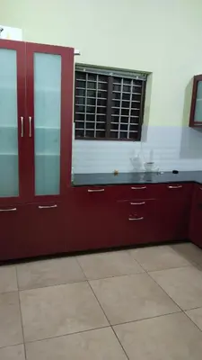 a kitchen with red cabinets and a window at ZAREPHATH PG Home in Trichūr