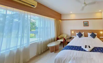 a bedroom with a bed and a large window at Hotel Amaravathi BY D2V in Manattala