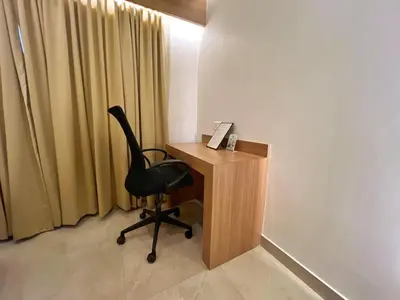 a desk with a chair in a room with a window at Hotel Amaravathi BY D2V in Manattala
