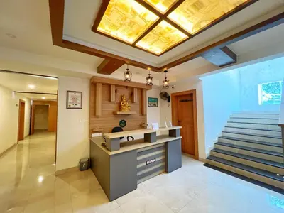 a lobby with a staircase and a skylight at Hotel Amaravathi BY D2V in Manattala