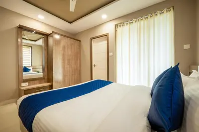 a bedroom with a large bed with blue pillows at Daan Temple Inn in Guruvāyūr