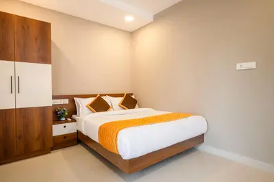 a bedroom with a bed and a wooden cabinet at Daan Temple Inn in Guruvāyūr