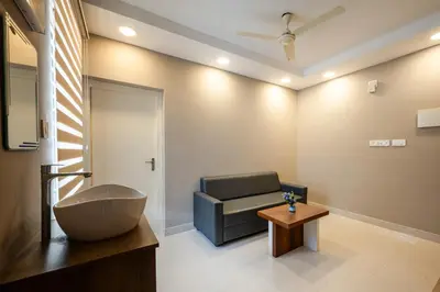 a bathroom with a couch and a chair and a table at Daan Temple Inn in Guruvāyūr