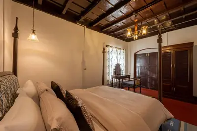 a bedroom with a bed and a table in a room at Sliceinn Escapes Pushpanjali - Madikeri, Coorg in Madikeri