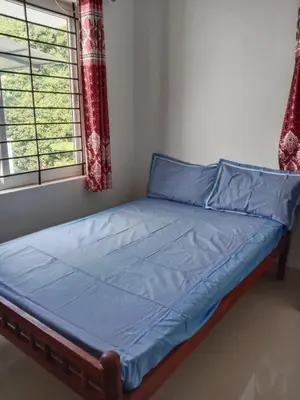 a bed with blue sheets in a room with two windows at Fully furnished 3BHK 2 Floor Villa in Angamali