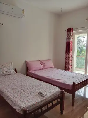 a bedroom with two beds and a window at Fully furnished 3BHK 2 Floor Villa in Angamali