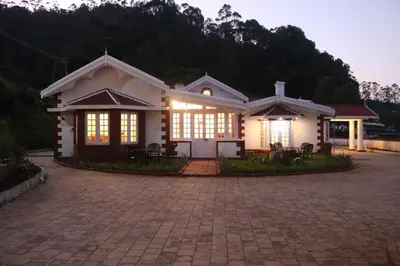 a house with lights on in a driveway at Jennings Abode Doddabetta in Ooty