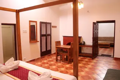 a living room with a table and a desk at Jennings Abode Doddabetta in Ooty