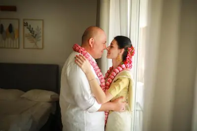 a bride and groom standing next to a window at Shoreline Secrets in Trichūr