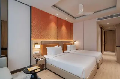 a hotel room with two beds and a couch at The Magnus in Coimbatore