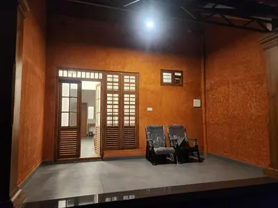 an empty stage with two chairs and an open door at Mana Gramam Resort Mudumalai- Only For Indians,NRI in Mudumalai National Park
