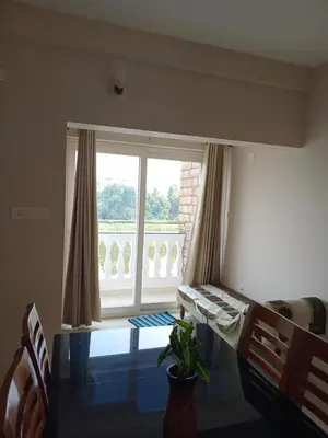 a room with a large window and a table with a plant at Dew Dreams Periyar Castle in Alwaye