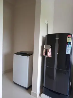 a black refrigerator next to a trash can at Dew Dreams Periyar Castle in Alwaye