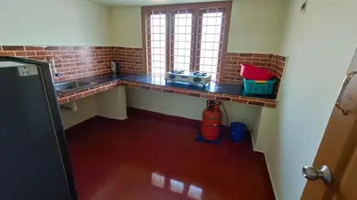 a kitchen with a counter with a sink and a window at Serenity Suite in Trichūr