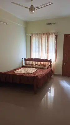 a large bed in a room with a window at Serenity Suite in Trichūr