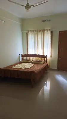 a large bed in a room with a window at Serenity Suite in Trichūr