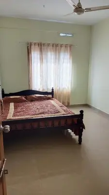 a large bed in a room with a window at Serenity Suite in Trichūr