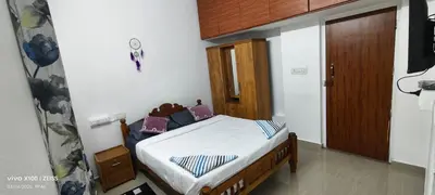 a small bedroom with a bed in a room at The Bulbul Nest Homestay in Gūdalūr