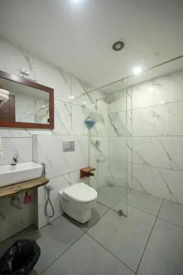 a bathroom with a toilet and a glass shower at Mayaahi Resorts & Spa in Nilambūr