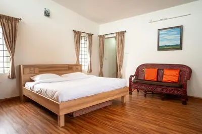 a bedroom with a bed and a chair at Greendale in Kotagiri