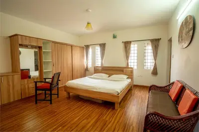 a bedroom with a bed and a couch and a chair at Greendale in Kotagiri