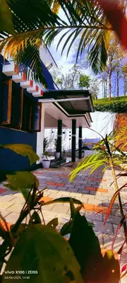 a building with a pavilion in front of it at The Bulbul Nest Homestay in Gūdalūr