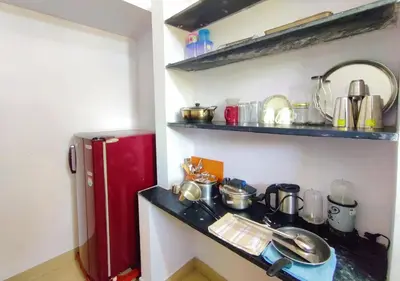 a small kitchen with a red refrigerator and shelves at Manasthala- Srinivas House Room1 in Mysore