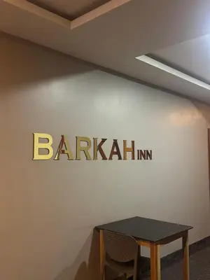 a sign on a wall with a table at Barkah inn in Kannur