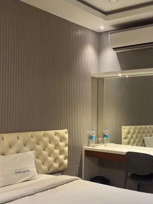 a hotel room with a bed and a desk at Barkah inn in Kannur