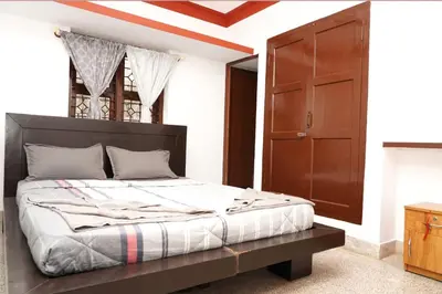 a bedroom with a large bed and a wooden door at Lands End in Madikeri
