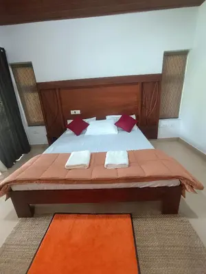 a bedroom with a large bed with red pillows at Bharathapuzha resort in Kārakkād